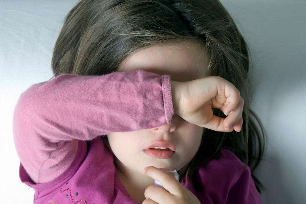 Dziewczynka zakrywająca oczy ręką